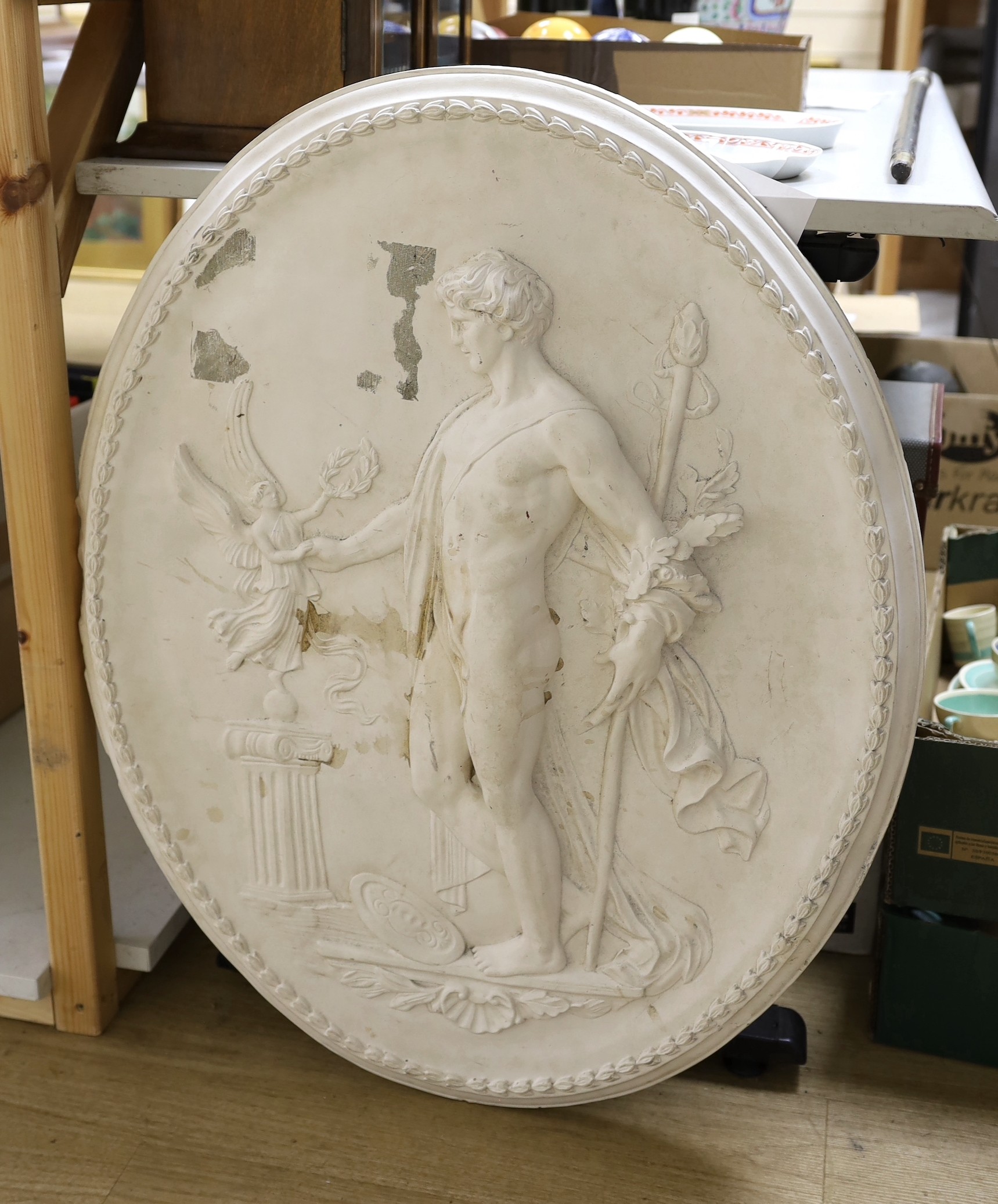 A cast plaster oval figural plaque, 84 cms high